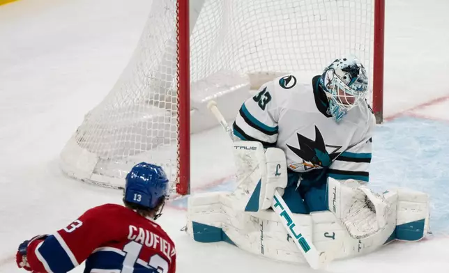 Montreal Canadiens' Cole Caufield (13) scores on San Jose Sharks goaltender Alex Nedeljkovic (33) during the first period of an NHL hockey game in Montreal, Saturday, March 14, 2026. (Christinne Muschi/The Canadian Press via AP)