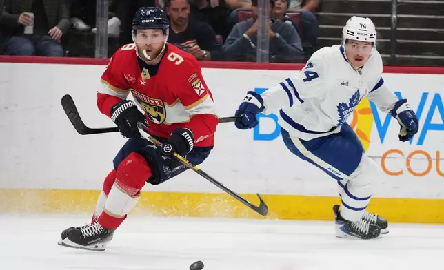 Florida Panthers center Sam Bennett (9) skates with the puck as Toronto Maple Leafs center Bobby McMann (74) defends during the first period of an NHL hockey game, Thursday, Feb. 26, 2026, in Sunrise, Fla. (AP Photo/Lynne Sladky)