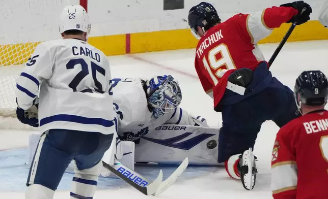 Toronto Maple Leafs goaltender Joseph Woll, left, defends a shot on the goal by Florida Panthers left wing Matthew Tkachuk (19) during the third period of an NHL hockey game, Thursday, Feb. 26, 2026, in Sunrise, Fla. (AP Photo/Lynne Sladky)