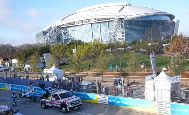 Emergency crew moves driver Josef Newgarden's car after he hit a wall during practice for IndyCar Grand Prix of Arlington auto race, Saturday, March 14, 2026, in Arlington, Texas. (AP Photo/LM Otero)