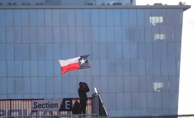 A lone auto race fan watches practice runs for the IndyCar Grand Prix of Arlington auto race, Saturday, March 14, 2026, in Arlington, Texas. (AP Photo/LM Otero)