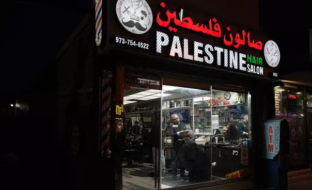 Raed Odeh, the owner and top barber of the Palestine Hair Salon trims the hair of a man in Paterson, N.J., during Ramadan on Friday, Feb. 27, 2026. (AP Photo/Luis Andres Henao)
