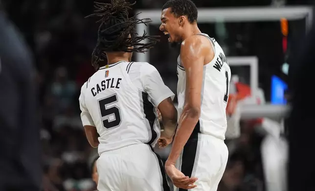 San Antonio Spurs forward Victor Wembanyama (1) celebrates a score with teammate Stephon Castle (5) during the second half of an NBA basketball game against the Charlotte Hornets in San Antonio, Saturday, March 14, 2026. (AP Photo/Eric Gay)