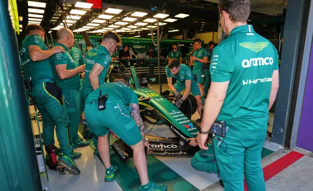 Mechanics work Aston Martin driver Lance Stroll of Canada's car in the team garage during the first practice session for the Australian Formula One Grand Prix at Albert Park, in Melbourne, Australia, Friday, March 6, 2026. (AP Photo/Asanka Brendon Ratnayake)