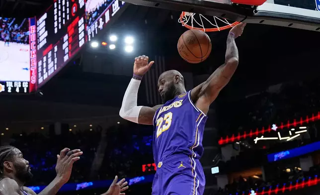 Los Angeles Lakers' LeBron James dunks the ball against the Houston Rockets during the second half of an NBA basketball game Wednesday, March 18, 2026, in Houston. (AP Photo/David J. Phillip)