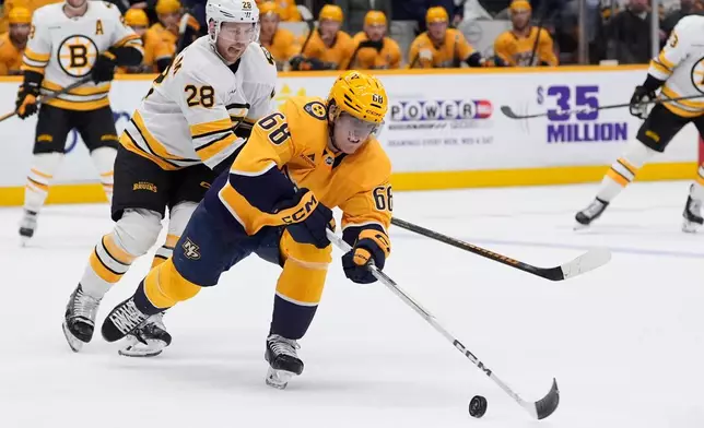 Nashville Predators left wing Zachary L'heureux (68) chases the puck past Boston Bruins center Elias Lindholm (28) during the first period of an NHL hockey game Thursday, March 5, 2026, in Nashville, Tenn. (AP Photo/George Walker IV)