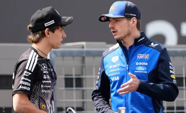 Red Bull driver Max Verstappen, right, of the Netherlands and Mercedes driver Kimi Antonelli of Italy talk during the drivers parade ahead of the Japanese Formula One Grand Prix at Suzuka in central Japan, Sunday, March 29, 2026. (AP Photo/Eugene Hoshiko)