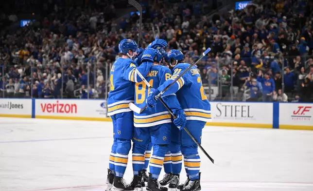 St. Louis Blues' Jimmy Snuggerud (21) celebrates with teammates after scoring a goal against the Toronto Maple Leafs' during the second period of an NHL hockey game Saturday, March 28, 2026, in St. Louis. (AP Photo/Connor Hamilton)
