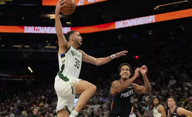 Milwaukee Bucks forward Pete Nance (35) shoots over Phoenix Suns forward Oso Ighodaro during the first half of an NBA basketball game, Saturday, March 21, 2026, in Phoenix. (AP Photo/Rick Scuteri)