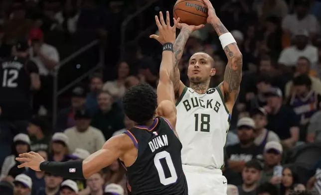 Milwaukee Bucks forward Kyle Kuzma shoots over Phoenix Suns forward Ryan Dunn (0) during the first half of an NBA basketball game, Saturday, March 21, 2026, in Phoenix. (AP Photo/Rick Scuteri)