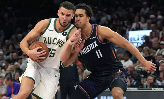 Milwaukee Bucks forward Pete Nance drives on Phoenix Suns forward Oso Ighodaro (11) during the first half of an NBA basketball game, Saturday, March 21, 2026, in Phoenix. (AP Photo/Rick Scuteri)