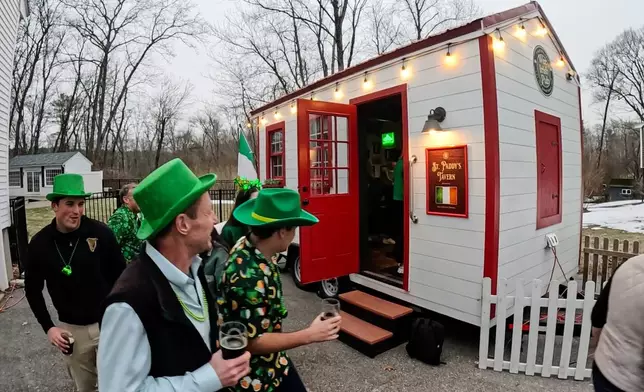 Revelers gather for an early St. Patrick's Day party in a rented tiny pub, Friday, March 13, 2026, in Andover, Mass. (AP Photo/Robert F. Bukaty)