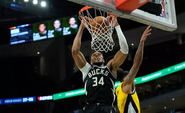 Milwaukee Bucks' Giannis Antetokounmpo (34) dunks past Indiana Pacers' Obi Toppin during the second half of an NBA basketball game, Sunday, March 15, 2026, in Milwaukee. (AP Photo/Aaron Gash)