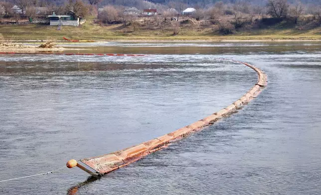 Chemical absorbent booms are placed in the Dniester river in Curesnita, Moldova, on the border with Ukraine, Tuesday, March 17, 2026. (AP Photo/Aurel Obreja)