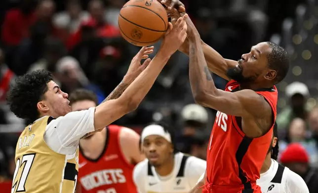 Washington Wizards guard Will Riley, left, and Houston Rockets forward Kevin Durant, right, compete the ball during the second half of an NBA basketball game, Monday, March 2, 2026, in Washington. (AP Photo/John McDonnell)