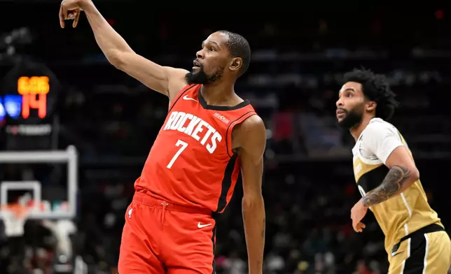 Houston Rockets forward Kevin Durant (7) watches his 3-point shot go in with Washington Wizards forward Justin Champagnie during the first half of an NBA basketball game, Monday, March 2, 2026, in Washington. (AP Photo/John McDonnell)