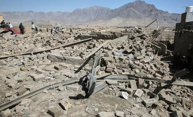 Residents gather at the site of a strike in Kabul, Afghanistan, Friday, March 13, 2026. (AP Photo/Barackatullah Popal)