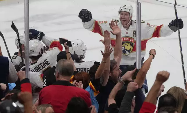 Florida Panthers center Carter Verhaeghe (23), left, celebrates his goal during the third period of an NHL hockey game against the Detroit Red Wings, Tuesday, March 10, 2026, in Sunrise, Fla. (AP Photo/Marta Lavandier)