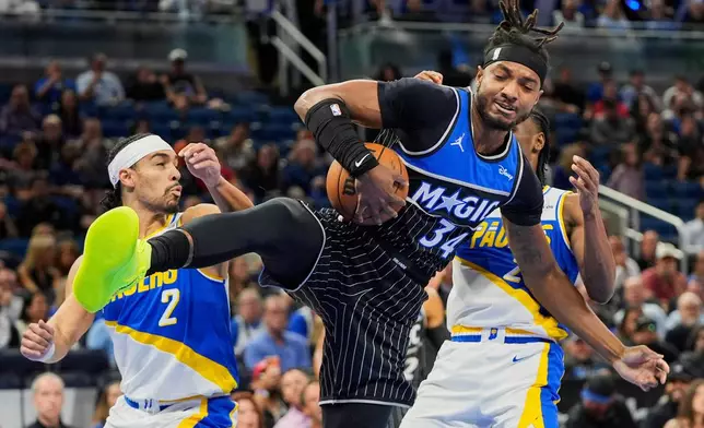 Orlando Magic center Wendell Carter Jr. (34) grabs a rebound in front of Indiana Pacers guard Andrew Nembhard (2) and guard Aaron Nesmith during the first half of an NBA basketball game, Monday, March 23, 2026, in Orlando, Fla. (AP Photo/John Raoux)