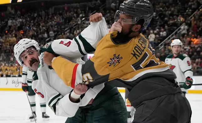 Minnesota Wild defenseman Jake Middleton, left, and Vegas Golden Knights right wing Keegan Kolesar (55) fight during the second period of an NHL hockey game Friday, March 6, 2026, in Las Vegas. (AP Photo/John Locher)