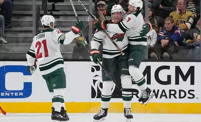 Minnesota Wild defenseman Brock Faber (7) celebrates withe Minnesota Wild center Michael McCarron (47) after McCarron scored against the Vegas Golden Knights during the second period of an NHL hockey game Friday, March 6, 2026, in Las Vegas. (AP Photo/John Locher)