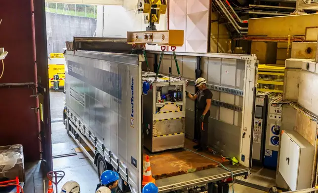 Technicians load the transportable antimatter trap into a truck from the Antimatter Factory at the European Organization for Nuclear Research (CERN) for a road test in Meyrin near Geneva, Switzerland, Tuesday, March 24, 2026. (Salvatore Di Nolfi/Keystone via AP)
