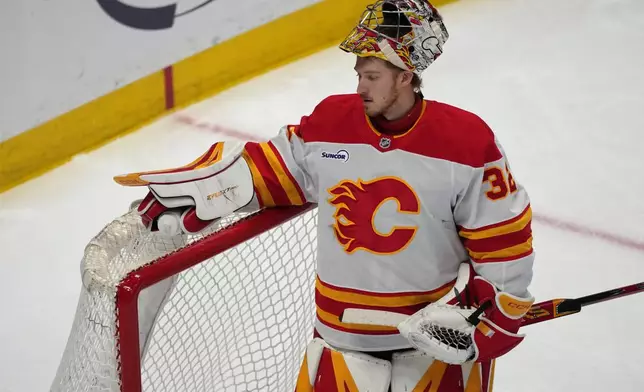 Calgary Flames goaltender Dustin Wolf reacts after giving up a goal to Colorado Avalanche center Jack Drury in the first period of an NHL hockey game, Monday, March 30, 2026, in Denver. (AP Photo/David Zalubowski)