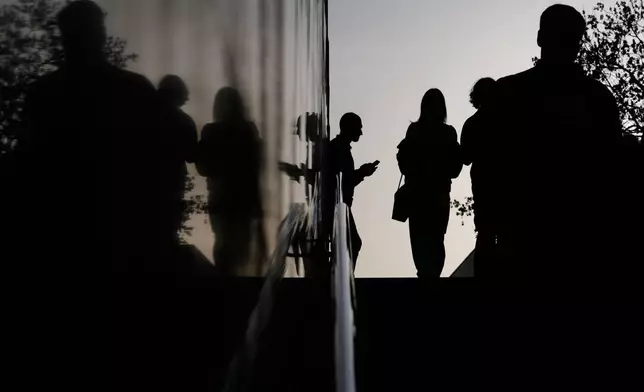 People enter an underpass during sunset in Moscow, Thursday, March 12, 2026. (AP Photo/Pavel Bednyakov)
