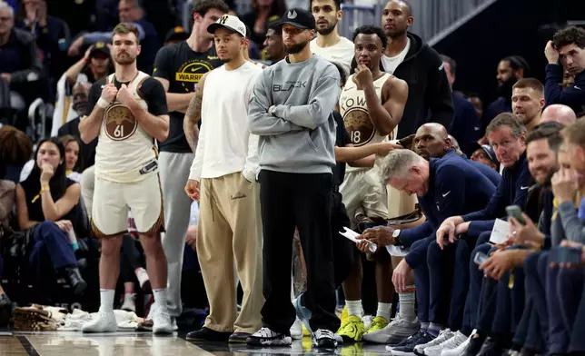 Golden State Warriors guard Stephen Curry watches from the bench during the second half of an NBA basketball game against the Brooklyn Nets in San Francisco, Wednesday, March 25, 2026. (AP Photo/Jed Jacobsohn)