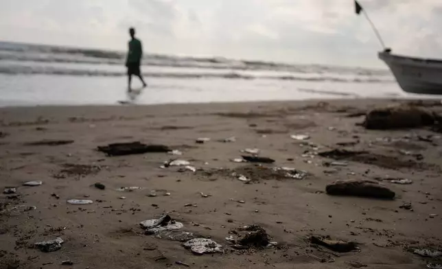 Clumps of oil residue lie on the shore after fishing outings were suspended because of an oil spill that Mexican authorities said originated from an unidentified vessel and two natural oil seeps along the Gulf coast in Salinas, Mexico, Thursday, March 26, 2026. (AP Photo/Felix Marquez)
