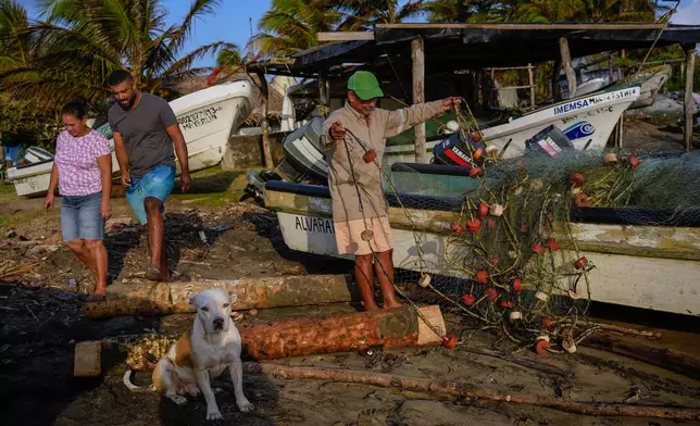 A fisherman untangles a net after suspending fishing outings because of an oil spill in the Gulf of Mexico that authorities said originated from an unidentified vessel and two natural oil seeps in Salinas, Mexico, Thursday, March 26, 2026. (AP Photo/Felix Marquez)