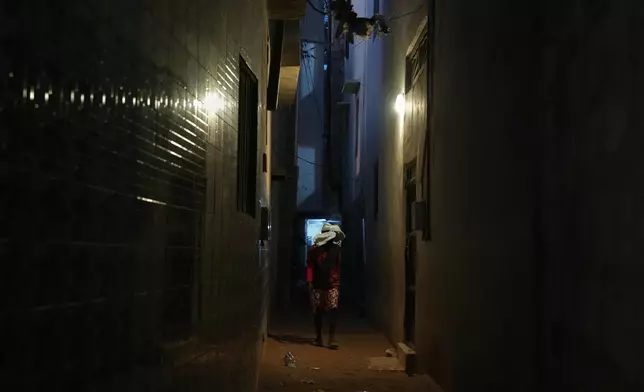 A young man disguises himself and walks through a neighbourhood in Dakar, Senegal, Thursday, March 12, 2026. (AP Photo/Misper Apawu)