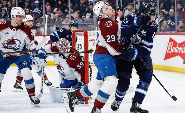 Winnipeg Jets' Gabriel Vilardi (13) and Colorado Avalanche's Nathan MacKinnon (29) collide during the second period of an NHL hockey game, in Winnipeg, Manitoba, Thursday, March 26, 2026. (John Woods/The Canadian Press via AP)
