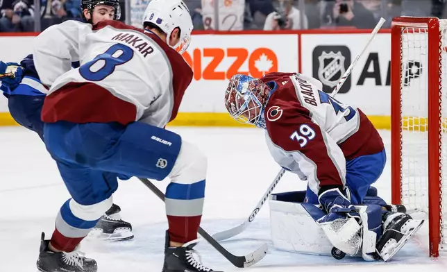 Colorado Avalanche's goaltender Mackenzie Blackwood (39) saves the shot from Winnipeg Jets' Isak Rosen (27) as Cale Makar (8) defends during the second period of an NHL hockey game, in Winnipeg, Manitoba, Thursday, March 26, 2026. (John Woods/The Canadian Press via AP)