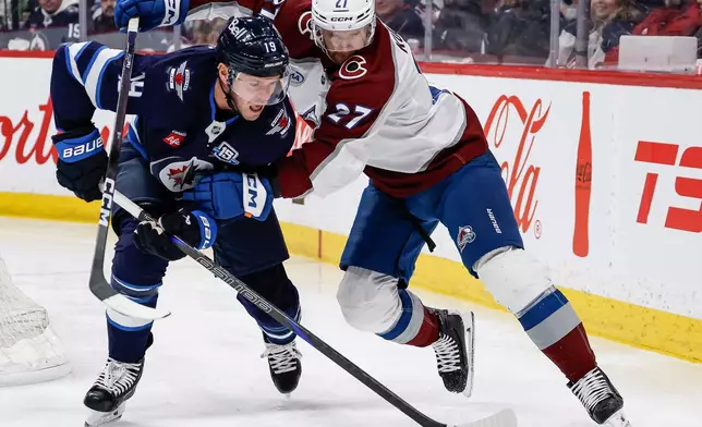 Colorado Avalanche's Brett Kulak (27) defends against Winnipeg Jets' Jonathan Toews (19) during second-period NHL hockey game action in Winnipeg, Manitoba, Thursday, March 26, 2026. (John Woods/The Canadian Press via AP)