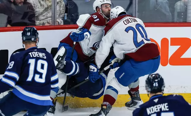 Colorado Avalanche's Gabriel Landeskog (92) and Ross Colton (20) collide with Winnipeg Jets' Dylan DeMelo (2) during the first period of an NHL game in Winnipeg, Thursday, March 26, 2026. (John Woods/The Canadian Press via AP)