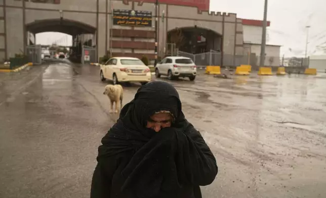 Iranian Kurdish Mariam crosses the Haji Omeran border crossing on foot between Iran and the autonomous Kurdistan Region of Iraq (KRI), Iraq, Sunday, March 15, 2026, as the border remains open. (AP Photo/Leo Correa)