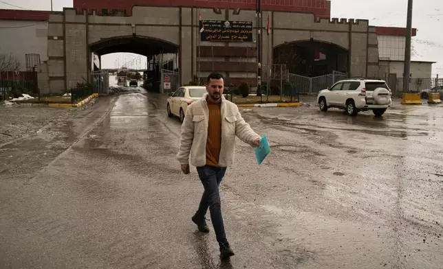 An Iranian Kurdish man crosses the Haji Omeran border crossing on foot between Iran and the autonomous Kurdistan Region of Iraq (KRI), Iraq, Sunday, March 15, 2026, as the border remains open. (AP Photo/Leo Correa)