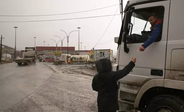 Trucks line up to cross into Iran at the Haji Omeran border crossing between Iran and the autonomous Kurdistan Region of Iraq (KRI), Iraq, Sunday, March 15, 2026.(AP Photo/Leo Correa)