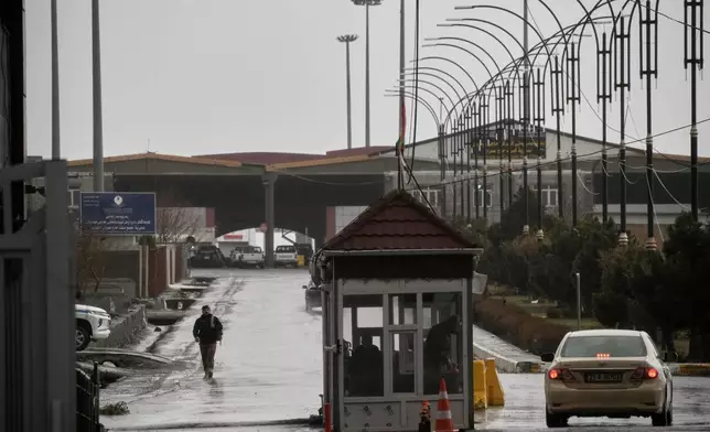 An Iraqi border officer walks toward the Iraqi side as cars cross the Haji Omeran border crossing between Iran and the autonomous Kurdistan Region of Iraq (KRI), Iraq, Sunday, March 15, 2026.(AP Photo/Leo Correa)