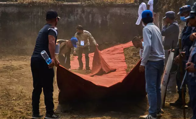 Rastriya Swatantra Party volunteers lay out a red carpet for their prime ministerial candidate, rapper-turned-politician Balendra Shah, during an election campaign rally in Chitwan, approximately 180 kilometers (112 miles) west of Kathmandu, Nepal, Friday, Feb. 27, 2026. (AP Photo/Niranjan Shrestha)
