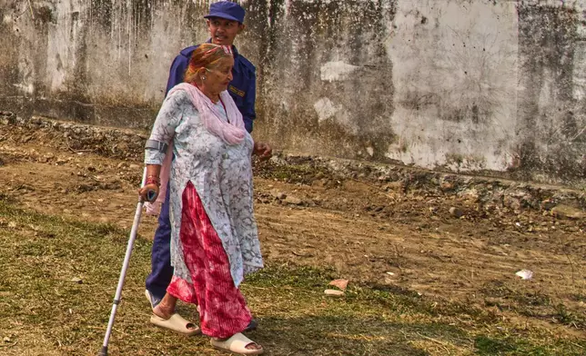 Tulasi Devi Shrestha, 75, a supporter of the Rastriya Swatantra Party, walks to an election rally for prime ministerial candidate and rapper-turned-politician Balendra Shah in Chitwan, approximately 180 kilometers (112 miles) west of Kathmandu, Nepal, Friday, Feb. 27, 2026. (AP Photo/Niranjan Shrestha)