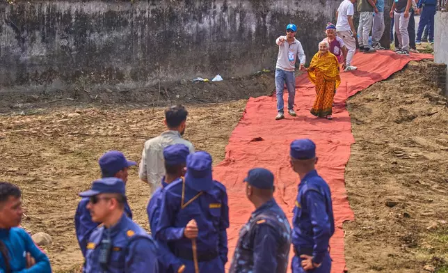A volunteer helps elderly Rastriya Swatantra Party supporters as they arrive for an election campaign rally for rapper-turned-politician Balendra Shah in Chitwan, approximately 180 kilometers (112 miles) west of Kathmandu, Nepal, Friday, Feb. 27, 2026. (AP Photo/Niranjan Shrestha)