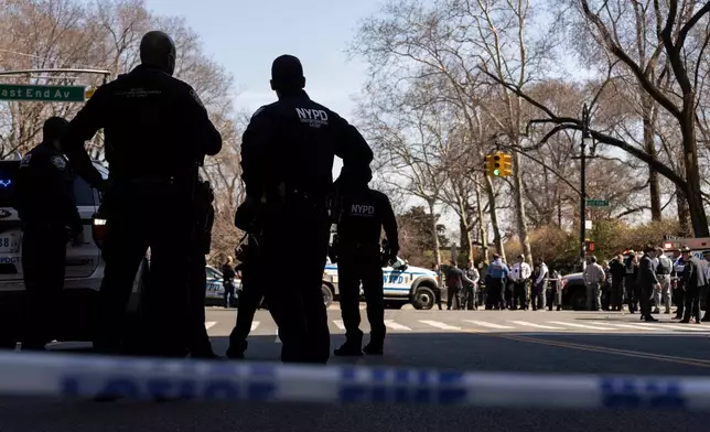 NYPD officers stand outside Carl Schurz Park as they investigate suspicious device, Tuesday, March 10, 2026, in New York. (AP Photo/Yuki Iwamura)