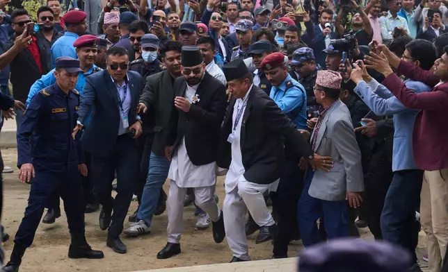 Balendra Shah, front center with sun glasses, arrives for a swearing-in ceremony of newly elected members of the House of Representatives at the Federal Parliament in Kathmandu, Nepal, Thursday, March 26, 2026. (AP Photo/Niranjan Shrestha)