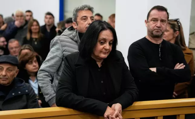 Relatives of victims of the Tempi train crash wait for the trial at the court in Larissa, Greece, Monday, March 23, 2026. (AP Photo/Thanassis Stavrakis)