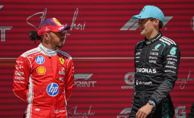 Winner Mercedes driver George Russell, right, of Britain talks with third placer Ferrari driver Lewis Hamilton of Britain after the Sprint Race of the Chinese Formula One Grand Prix at the Shanghai International Circuit, in Shanghai, China, Saturday, March 14, 2026. (AP Photo/Andy Wong)