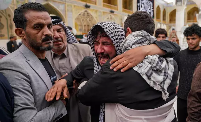 Relatives grieve an Iraqi soldier killed in a strike Wednesday on a military clinic in western Iraq's Anbar province, during a mass procession inside the shrine of Imam Ali in Najaf, Iraq, Thursday, March 26, 2026. (AP Photo/Anmar Khalil)