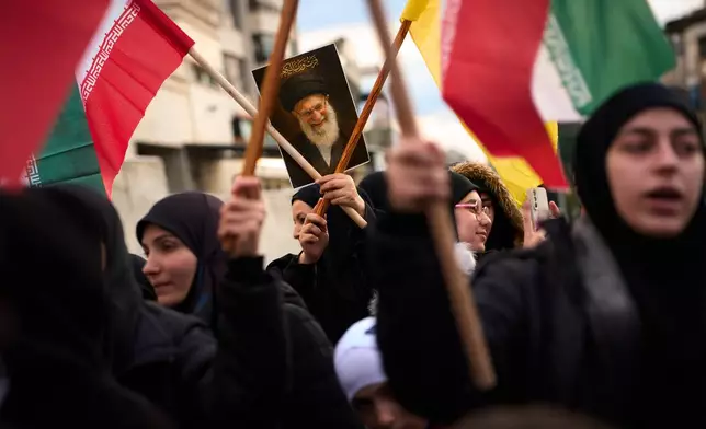 A woman holds a portrait of Iran's late Supreme Leader Ayatollah Ali Khamenei during a protest outside Iran's embassy, where dozens of people gathered waving Hezbollah and Iranian flags in solidarity with the Islamic Republic, in Beirut, Lebanon, Thursday, March 26, 2026. (AP Photo/Emilio Morenatti)