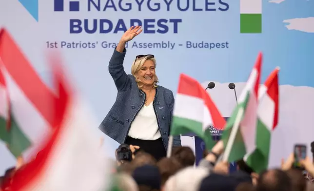 France's Marine Le Pen waves after speaking at an assembly of European far-right parties with Hungarian Prime Minister Viktor Orbán Patriots for Europe group, in Budapest, Hungary, Monday, March 23, 2026. (AP Photo/Denes Erdos)